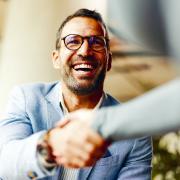 Ein Mann schüttelt die Hand einer anderen Person