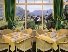 Hotel Hollweger Blick auf einen gedeckten Tisch mit Aussicht auf den Wolfgangsee vom Hotel Hollweger Wintergarten aus