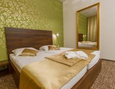 Doppelzimmer mit goldenen Akzenten und hellgrüner Tapete im Rimske Terme Hotel Rimski dvor